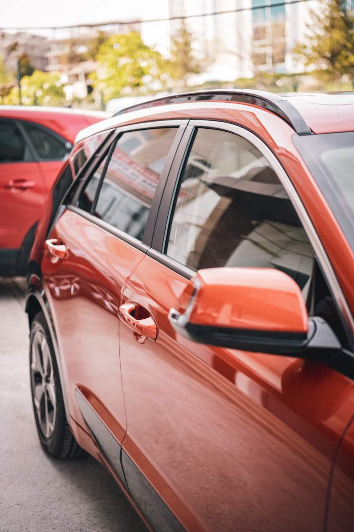 Contact Close-up of a red crossover vehicle parked in a modern urban environment.