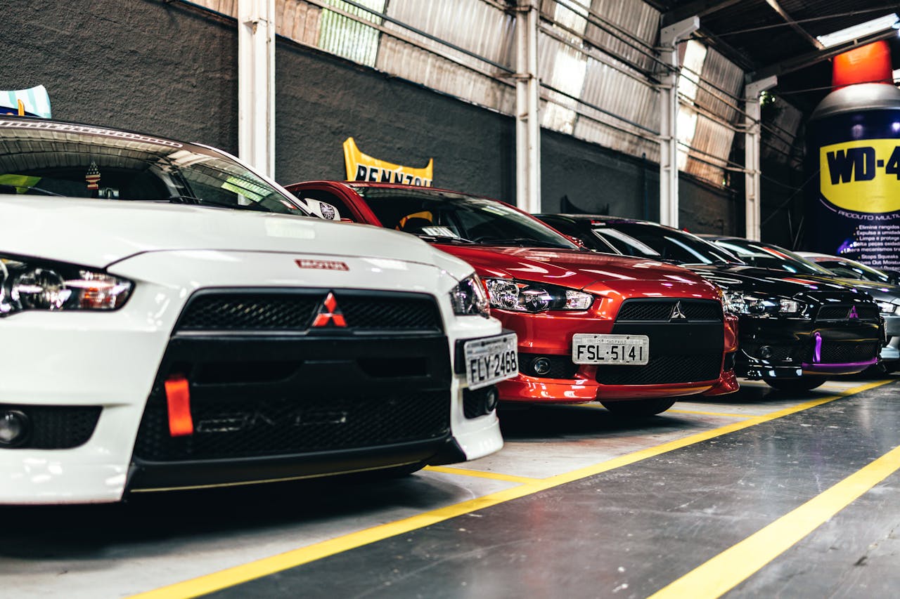 Close-up of parked Mitsubishi Lancer cars in an indoor lot featuring a variety of colors.