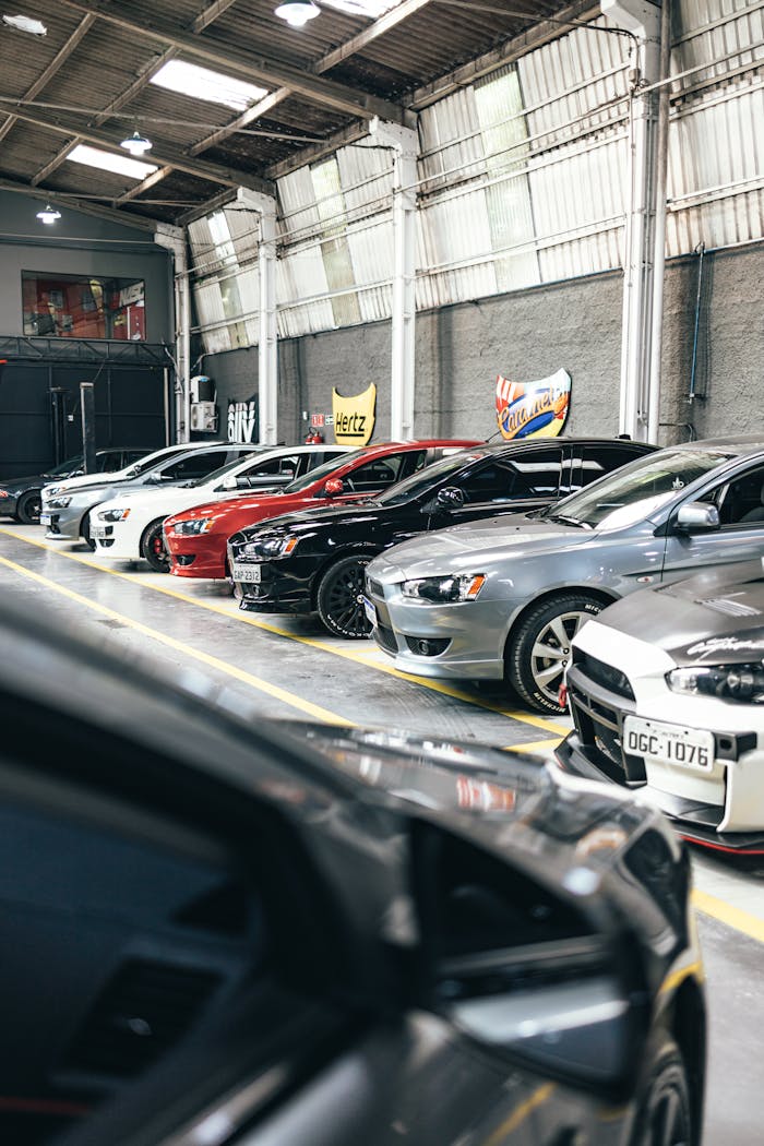 Rows of modern cars parked in a well-lit indoor parking garage, showcasing diverse models.